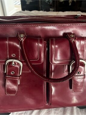 Burgundy Franklin Covey rolling laptop briefcase with matching zipper pouch.